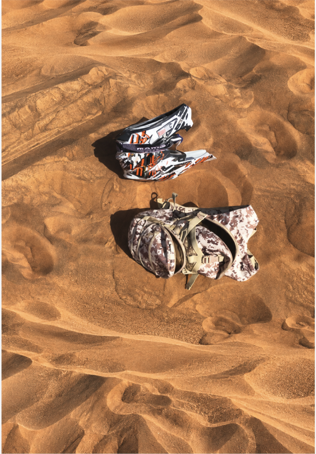 Quad bike helmet and backpack resting on the red dunes
