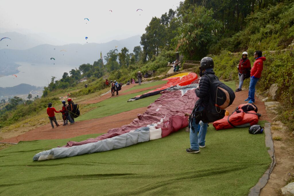 Paragliding wings laid out on the launch hill above Pokhara